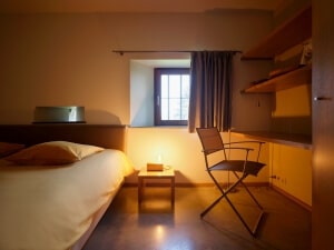 Gezellig ingerichte kamer met comfortabel bed en uitzicht op het omliggende landschap